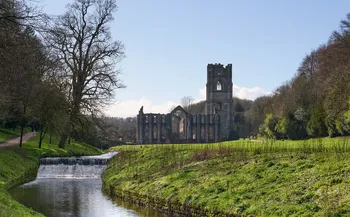 Looking towards Fountains abbey from the River Skell on a sunny spring day wide.jpg